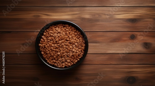 Top view of pet food in bowl on wooden table