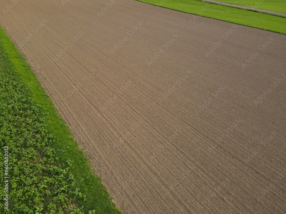 Drone view of a plowed agriculture field with soil in the countryside 