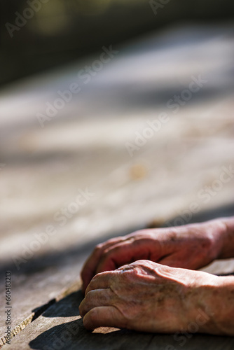 Weathered hands meet nature's tranquil backdrop