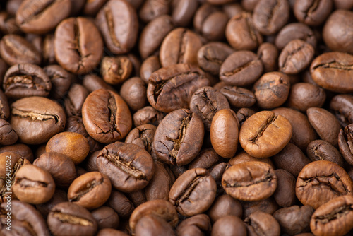 Close up of dark roasted coffee beans. Fresh aromatic coffee grain background