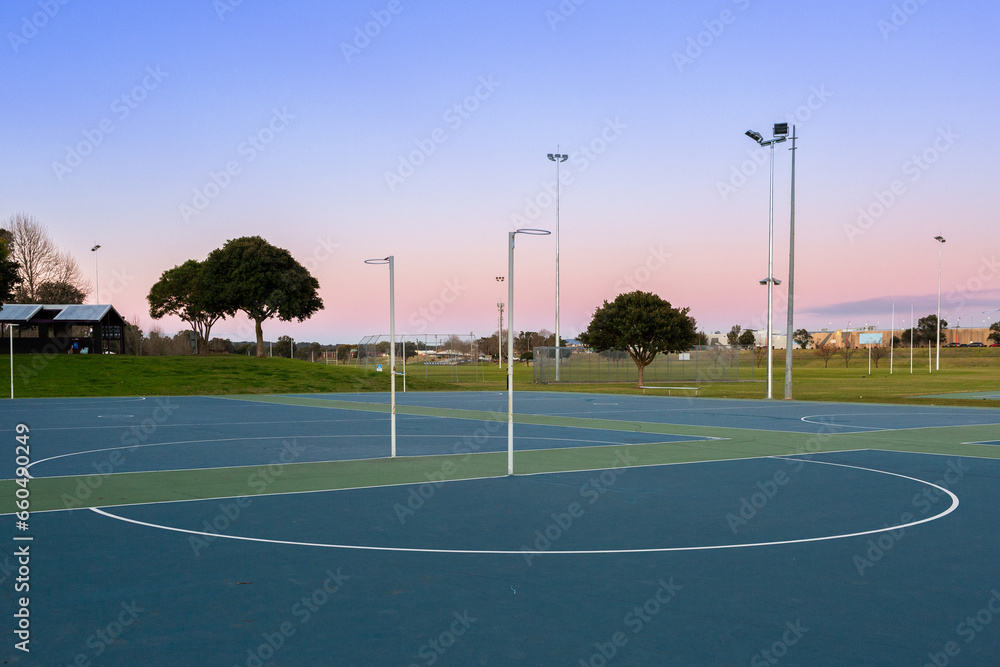 Netball hoop at empty community sports ground in dusk light