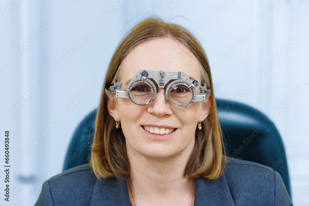 Middle-aged woman wearing glasses for eye exam in ophthalmologist's office. Middle-aged woman wearing glasses for eye exam in ophthalmologist's office.