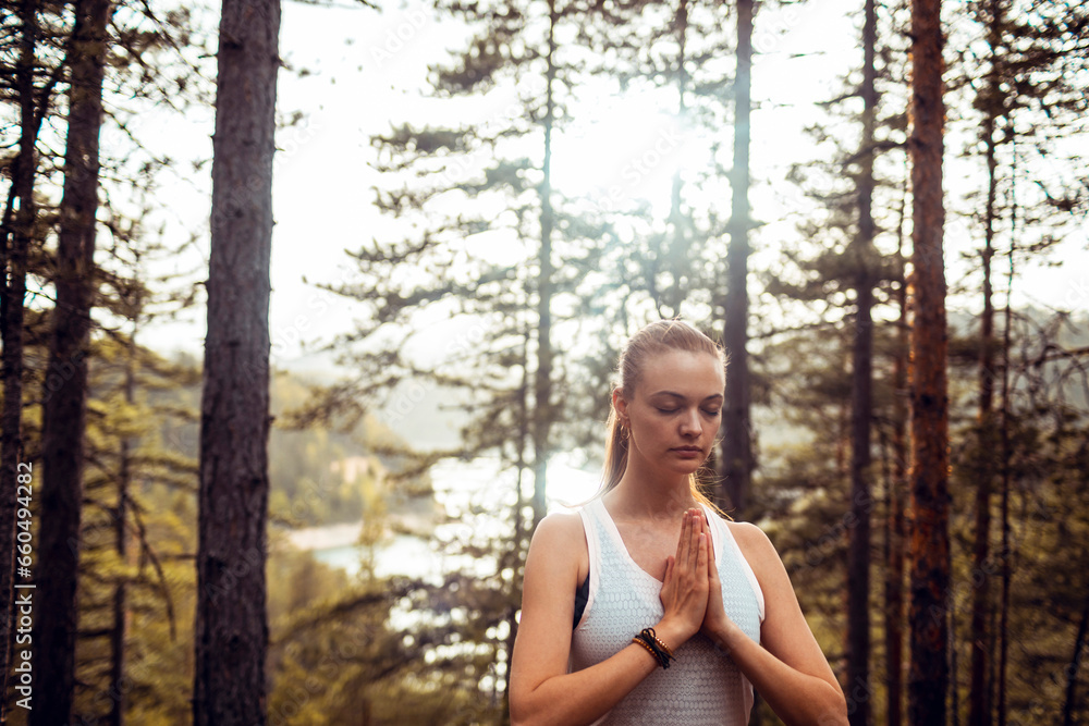 Young fit woman meditating in the woods Young fit woman meditating in the woods