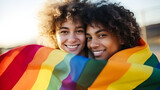 Joyful women in a loving embrace, holding a vibrant rainbow flag outdoors. A heartwarming depiction of LGBTQ+ love and pride. Ideal for championing diversity and celebrating love in all its forms