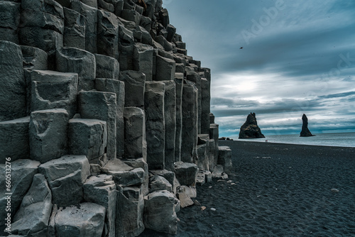 Reynisdrangar natural rock formation on Reynisfjara black sand beach in gloomy day at Iceland photo