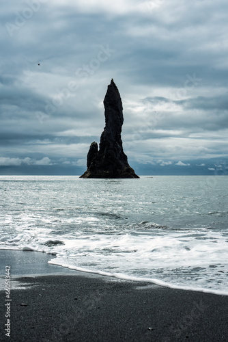 Moody Reynisdragar natural rock formation on Reynisfjara black sand beach in Atlantic ocean at Iceland © Mumemories