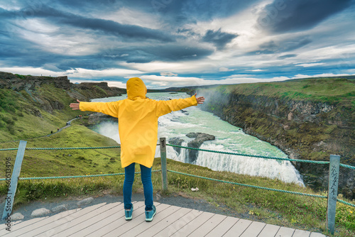 Female tourist enjoying on viewpoint of Gullfoss waterfall with hvita river flowing in canyon at Iceland photo