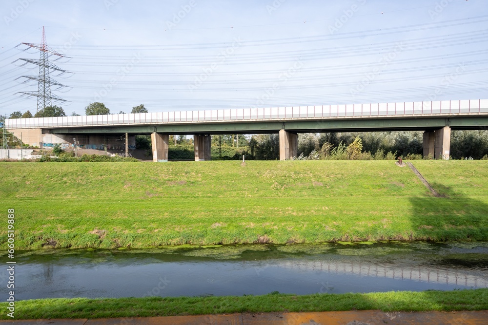 long motorway bridge with meadow and small canal in front long motorway bridge with meadow and small canal in front