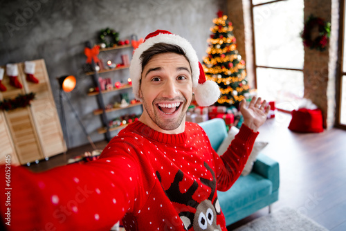 Photo of excited positive funky person make selfie arm demonstrate welcome newyear decorated house indoors