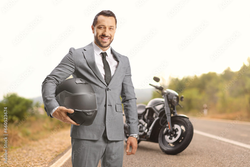 Businessman holding a helmet in front of a chopper Businessman holding a helmet in front of a chopper
