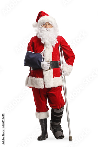 Tableau sur toile Santa claus with a foot brace and arm sling leaning on a crutch