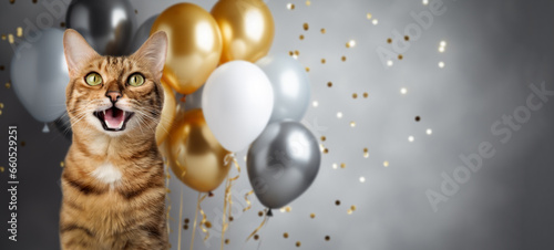 Funny portrait of a happy smiling bengal cat on a festive background with balloons and confetti.