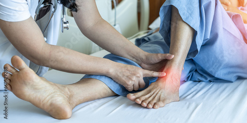 Ankle pain from instability, arthritis, gout, tendonitis, fracture, nerve compression (tarsal tunnel syndrome), infection and poor structural alignment of leg or foot in ageing patient with doctor © Chinnapong