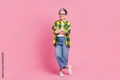 Full length photo of thoughtful minded woman wear checkered shirt look at offer empty space hand on chin isolated on pink color background