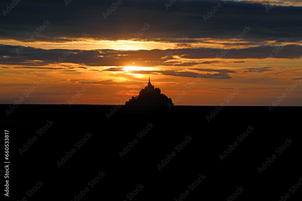 abbey of Mont saint-michel in Normandy in France at sunset with red sky