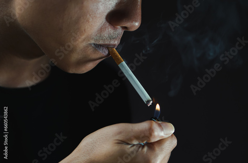 A man smoking cigarette in dark room