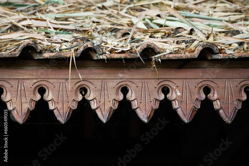 Omah Limasan or Traditional javanese joglo house or rumah joglo roof with ornament is covered with dried bamboo leaves. Concept for dry season, drought, autumn, rural village housing and storm.