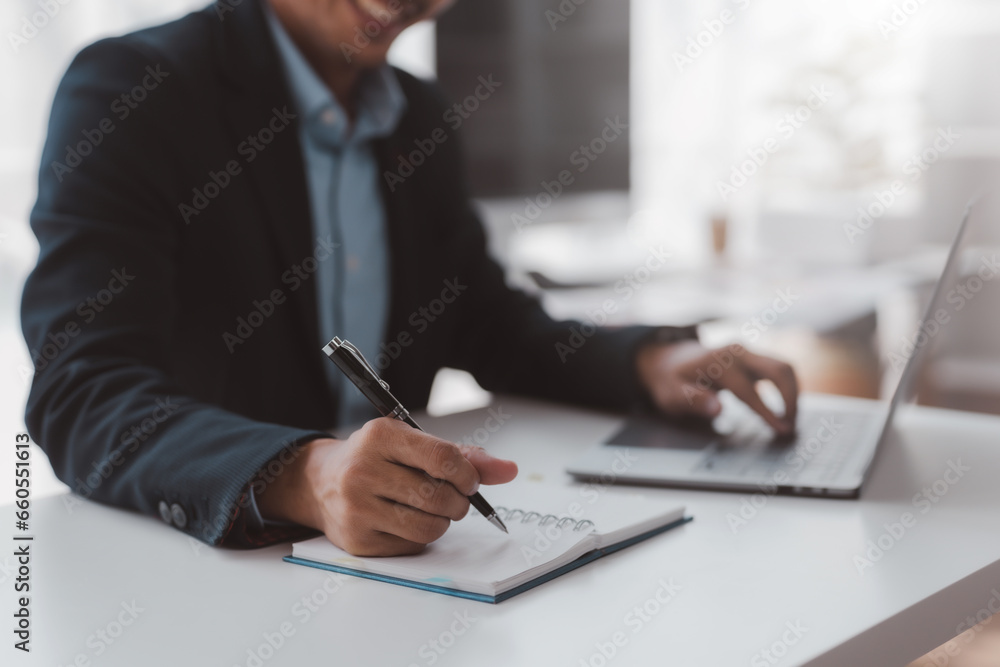 Closeup shot of businessman hand using pen and writing in notebook, presentation, working project at workplace. Man taking notes, typing on keyboard. Closeup shot of businessman hand using pen and writing in notebook, presentation, working project at workplace. Man taking notes, typing on keyboard.