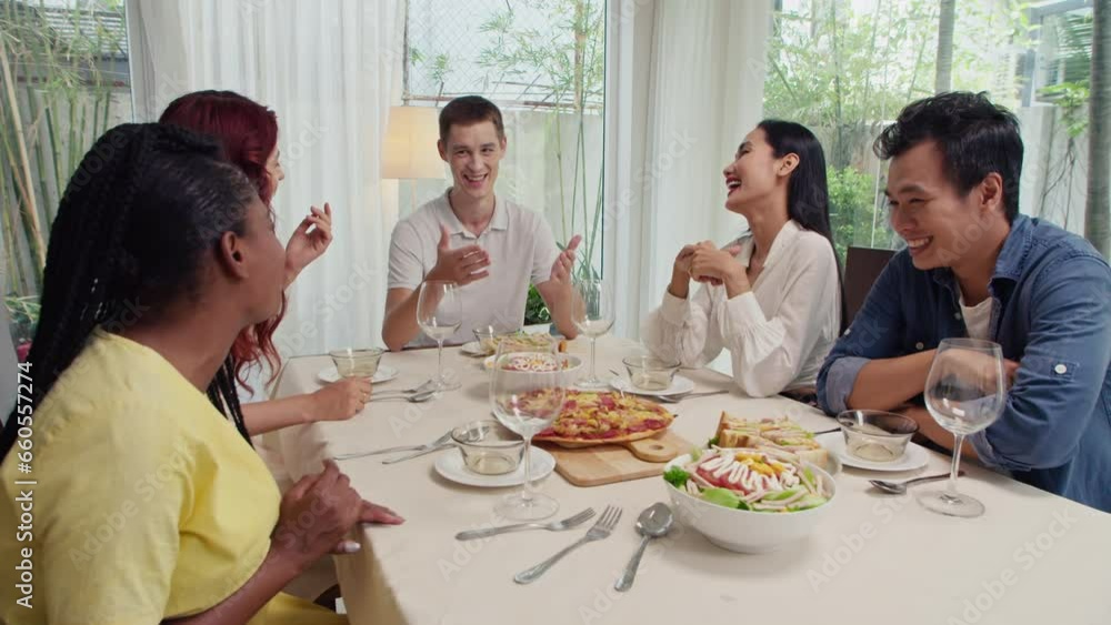 Medium long shot of happy friends talking to each other and laughing while celebrating event, sitting at festive table Medium long shot of happy friends talking to each other and laughing while celebrating event, sitting at festive table