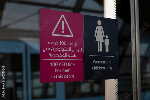 Sign in Arab and English women and children only at the subway special wagon, 100 AED fine for men in this cabin. Dubai, United Arab Emirates. photo