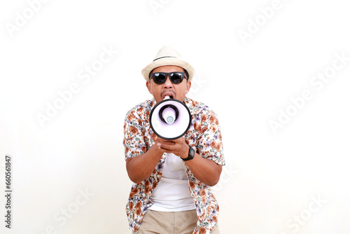 Asian adult man tourist holding a megaphone while screaming. Concept of travel. Isolated on white photo