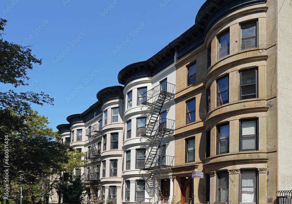 Street of old fashioned townhouses in New York City with curved fronts