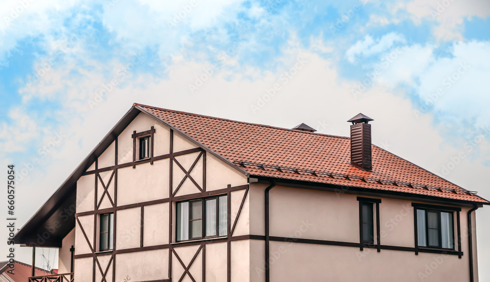 The upper part of the roof of a very neat and colorful house. The roof of the house from a metal profile against the sky The upper part of the roof of a very neat and colorful house. The roof of the house from a metal profile against the sky