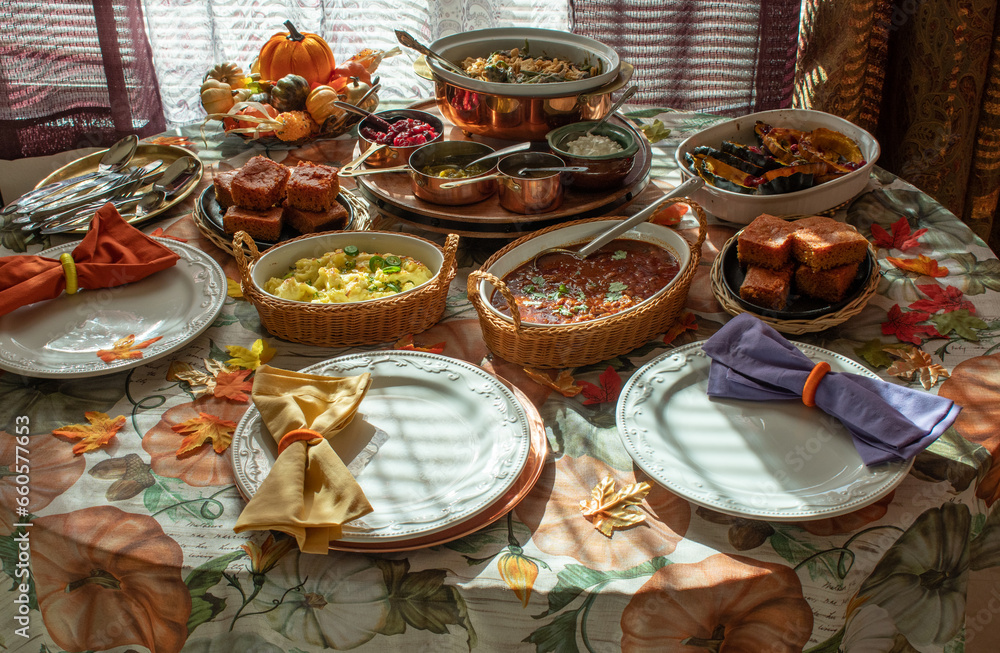 Vegan  Thanksgiving table setting consisting of traditional but vegan dishes: beans, chili, corn bread, roasted squash, mashed potatoes
