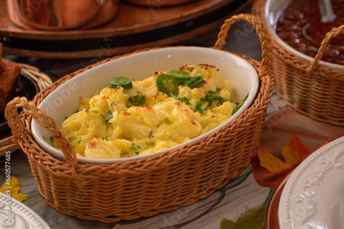 Vegan mashed poatoes as part of a plant-based Thanksgiving table setting, served in vintage ceramic and  wicker woven basket