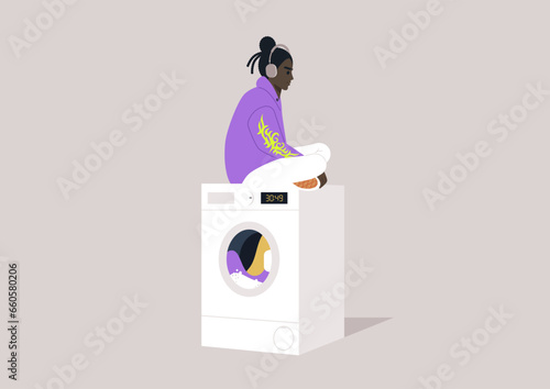 A youthful character in a hoodie, wearing oversized headphones, seated atop a washing machine while patiently awaiting the completion of their laundry