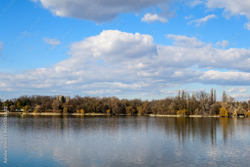 Landscape with large old trees near Herastrau lake in King Michael I Park (Herastrau) in Bucharest, Romania, in a sunny winter day