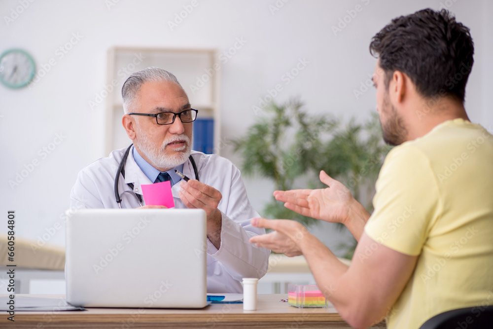 Young male patient visiting old male doctor Young male patient visiting old male doctor