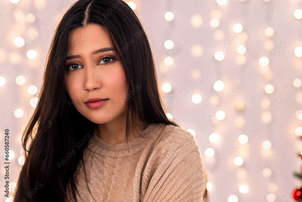 Fototapeta premium Christmas portrait of a beautiful brunette woman with brown eyes and a gray winter sweater