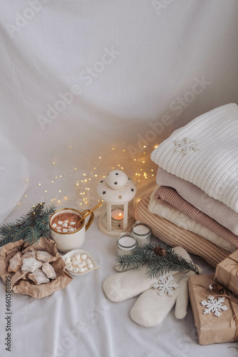 Cozy home interior with knitted sweaters, candles and Christmas decorations