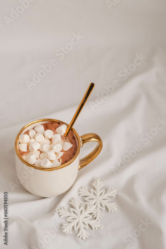 Cup of hot chocolate with marshmallows and snowflakes on a white background