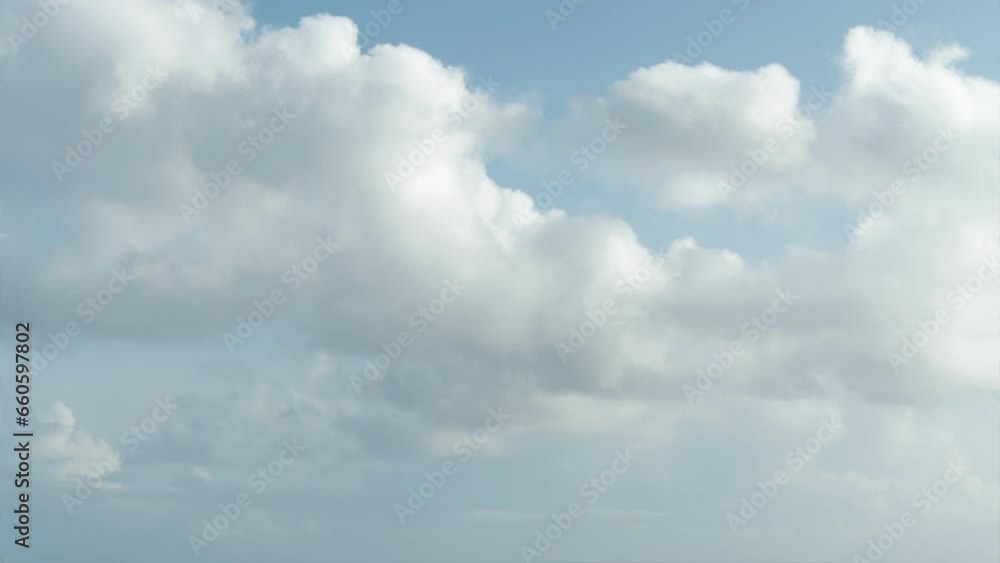 A light blue sky scattered with fluffy, white cumulus clouds. A light blue sky scattered with fluffy, white cumulus clouds.