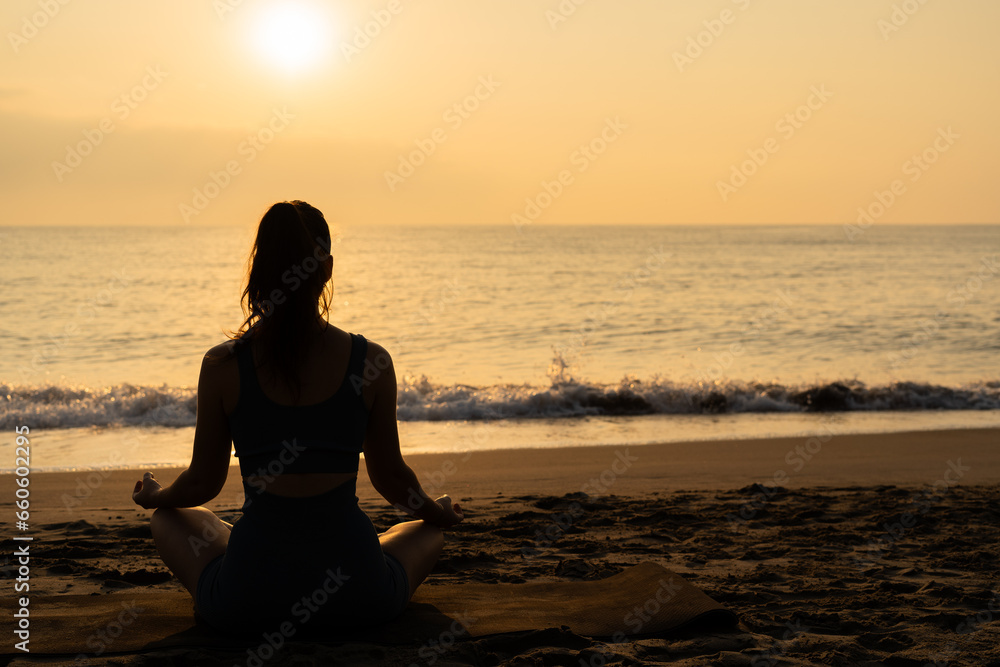 meditation and yoga on the beach. concept of doing yoga by the sea. woman in lotus position at dawn
