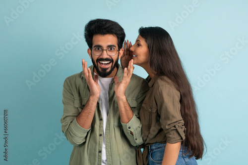 Long-haired young indian woman whispering something to her boyfriend