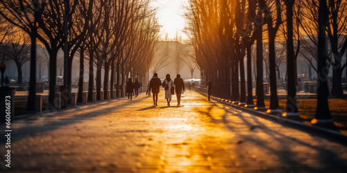 Blurred people walking in Korean park at late afternoon, long shadows, defocused image, background.