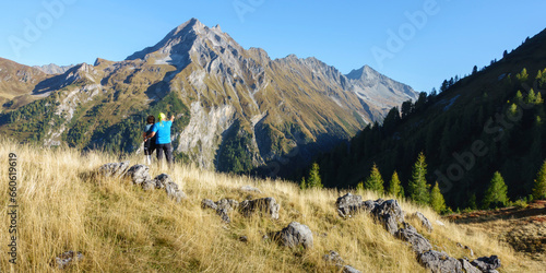 Panorama von zwei Wanderern die auf einen Berggipfel im Zillertal blicken photo