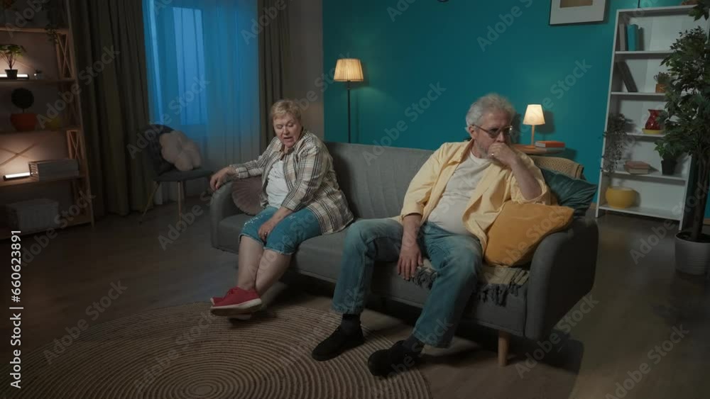 In the frame, an elderly couple sitting on opposite sides on a couch. They demonstrate quarrel, resentment, anger, sadness. Turning away from each other, they say something, continue to quarrel In the frame, an elderly couple sitting on opposite sides on a couch. They demonstrate quarrel, resentment, anger, sadness. Turning away from each other, they say something, continue to quarrel