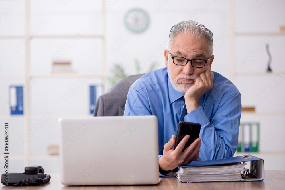 Old male employee working in the office Old male employee working in the office
