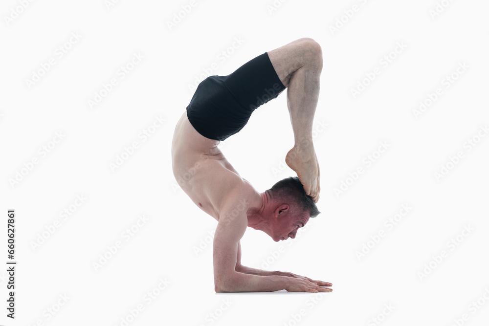 Scorpion Pose (Vrschikasana), Ashtanga yoga Side view of man wearing sportswear doing Yoga exercise against white background. Horizontal image. Scorpion Pose (Vrschikasana), Ashtanga yoga Side view of man wearing sportswear doing Yoga exercise against white background. Horizontal image.