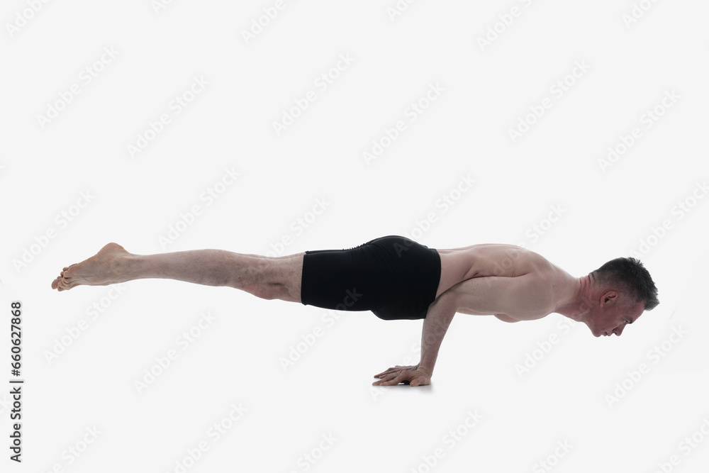 Mayurasana (Peacock Posture), Ashtanga yoga Side view of man wearing sportswear doing Yoga exercise against white background. Mayurasana (Peacock Posture), Ashtanga yoga Side view of man wearing sportswear doing Yoga exercise against white background.