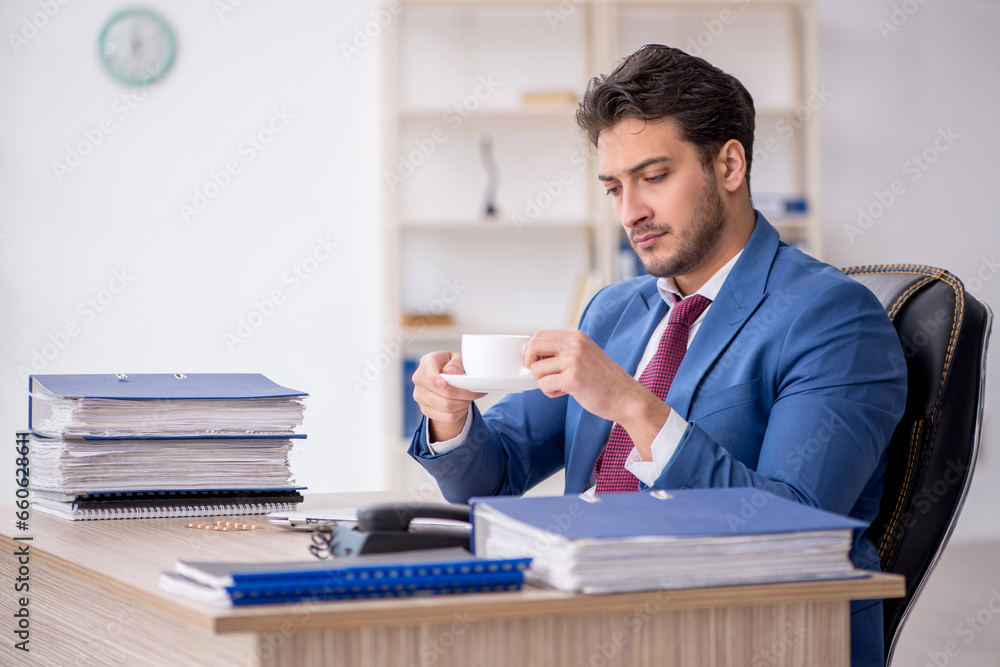 Young male employee drinking coffee during break