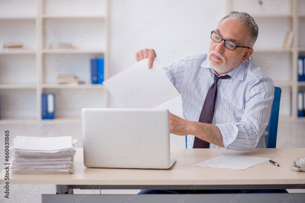 Old male employee working in the office Old male employee working in the office