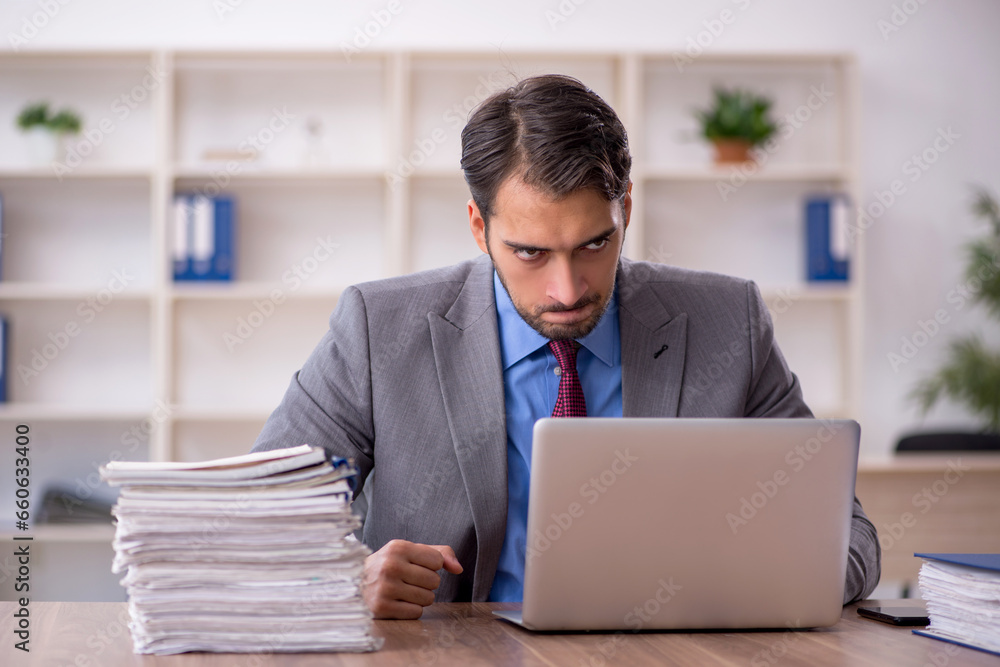 Young male employee working in the office Young male employee working in the office