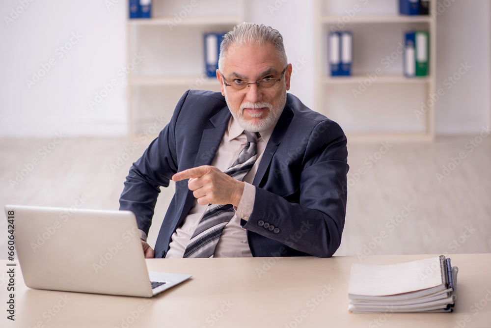 Old male employee working in the office Old male employee working in the office