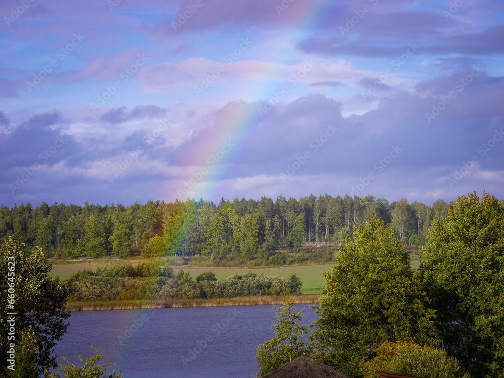 Scenic view of rainbow over lake against sky Scenic view of rainbow over lake against sky