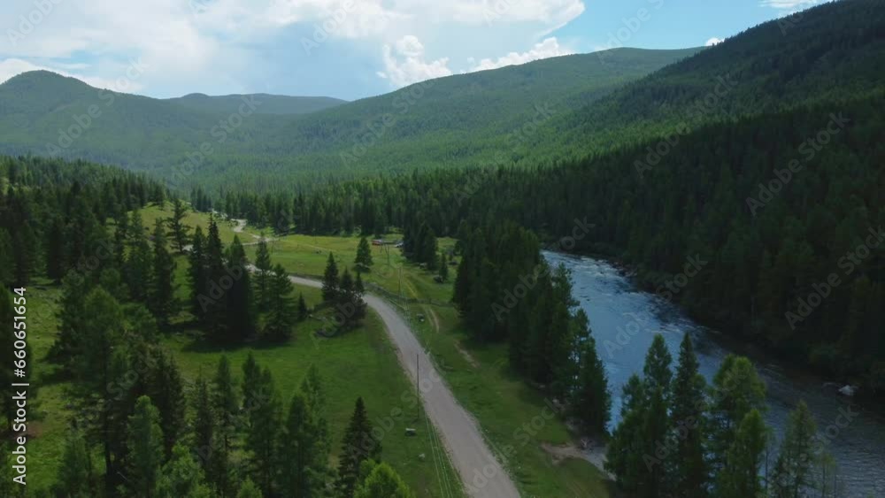 Aerial view of a green mountain landscape where a river flows from the mountains, and a beautiful coniferous forest is spread. Aerial view of a green mountain landscape where a river flows from the mountains, and a beautiful coniferous forest is spread.